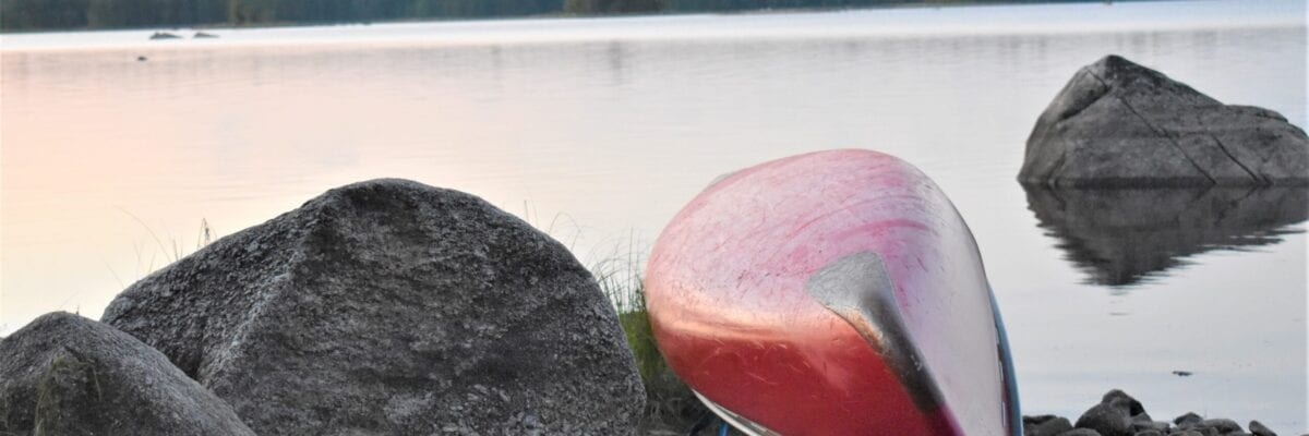 photo of upside down canoe on rocky maine lake shore