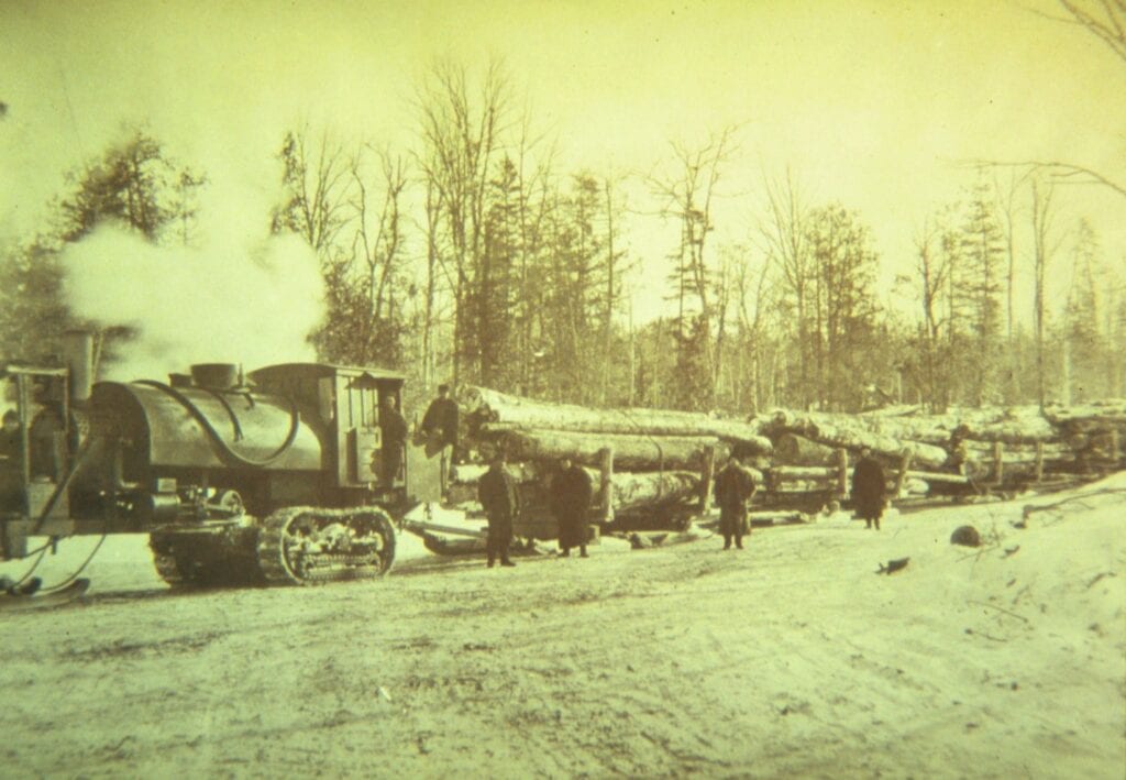 black and white photo of log hauling train in winter